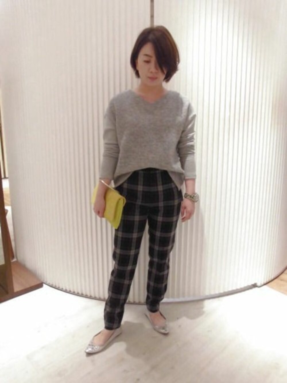グレー系のその他パンツ、グレー系のTシャツ/カットソー、グリーン系のクラッチバッグを着用したレディースの秋コーディネートの1枚目の写真