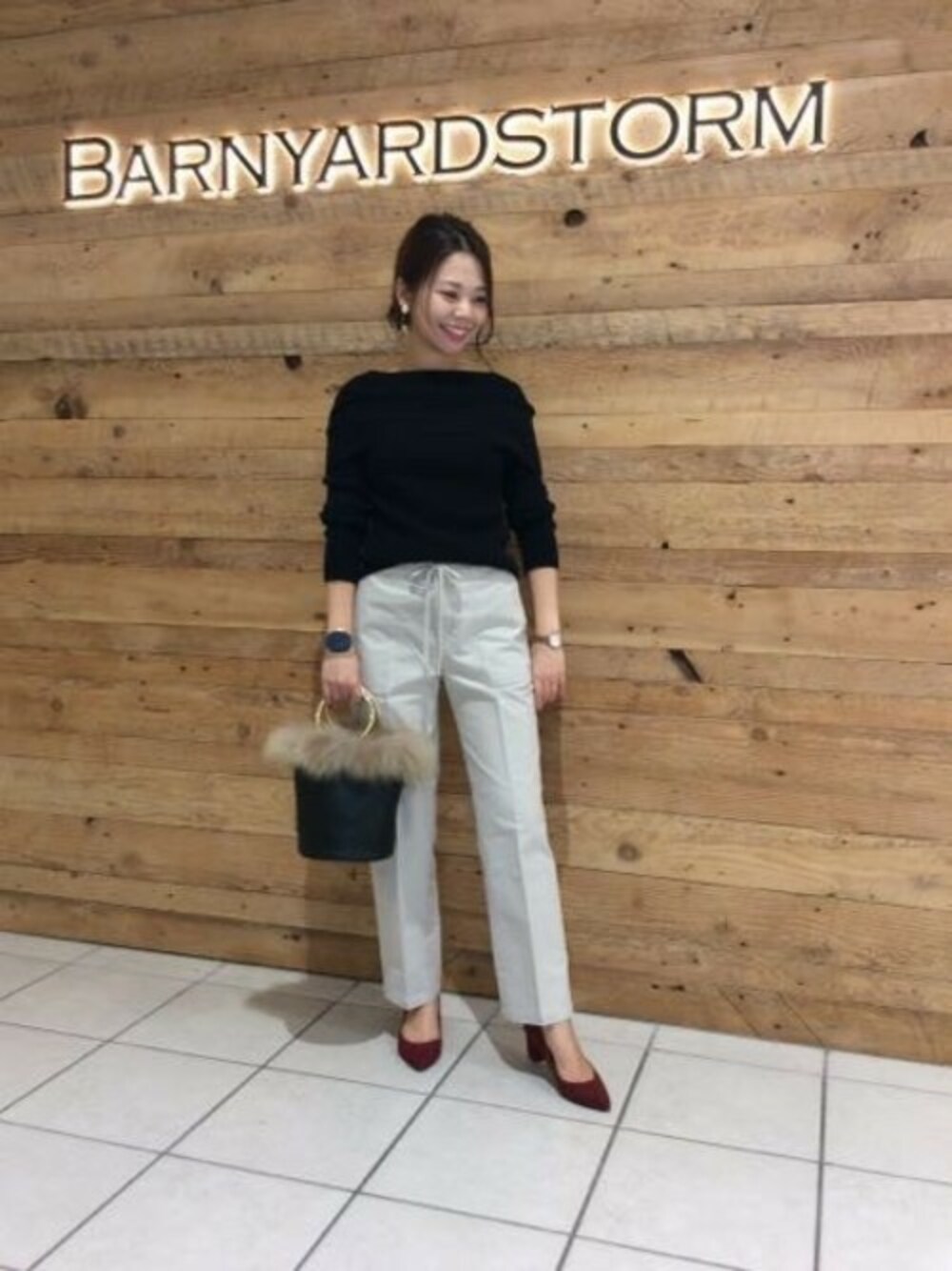 ブラック系のニット/セーター、ベージュ系のその他パンツ、ブラック系のショルダーバッグを着用したレディースの秋コーディネートの1枚目の写真