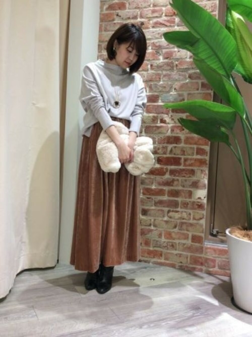 ベージュ系のTシャツ/カットソー、ピンク系のスカート、ホワイト系のネックウォーマー/スヌードを着用したレディースの秋コーディネートの1枚目の写真