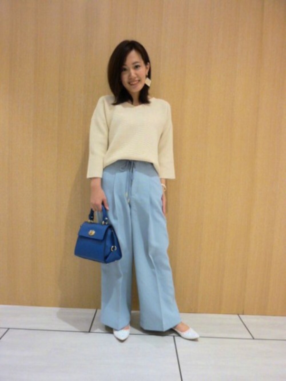 ブルー系のショルダーバッグ、ホワイト系のその他シューズ、ホワイト系のニット/セーターを着用したレディースの冬コーディネートの1枚目の写真