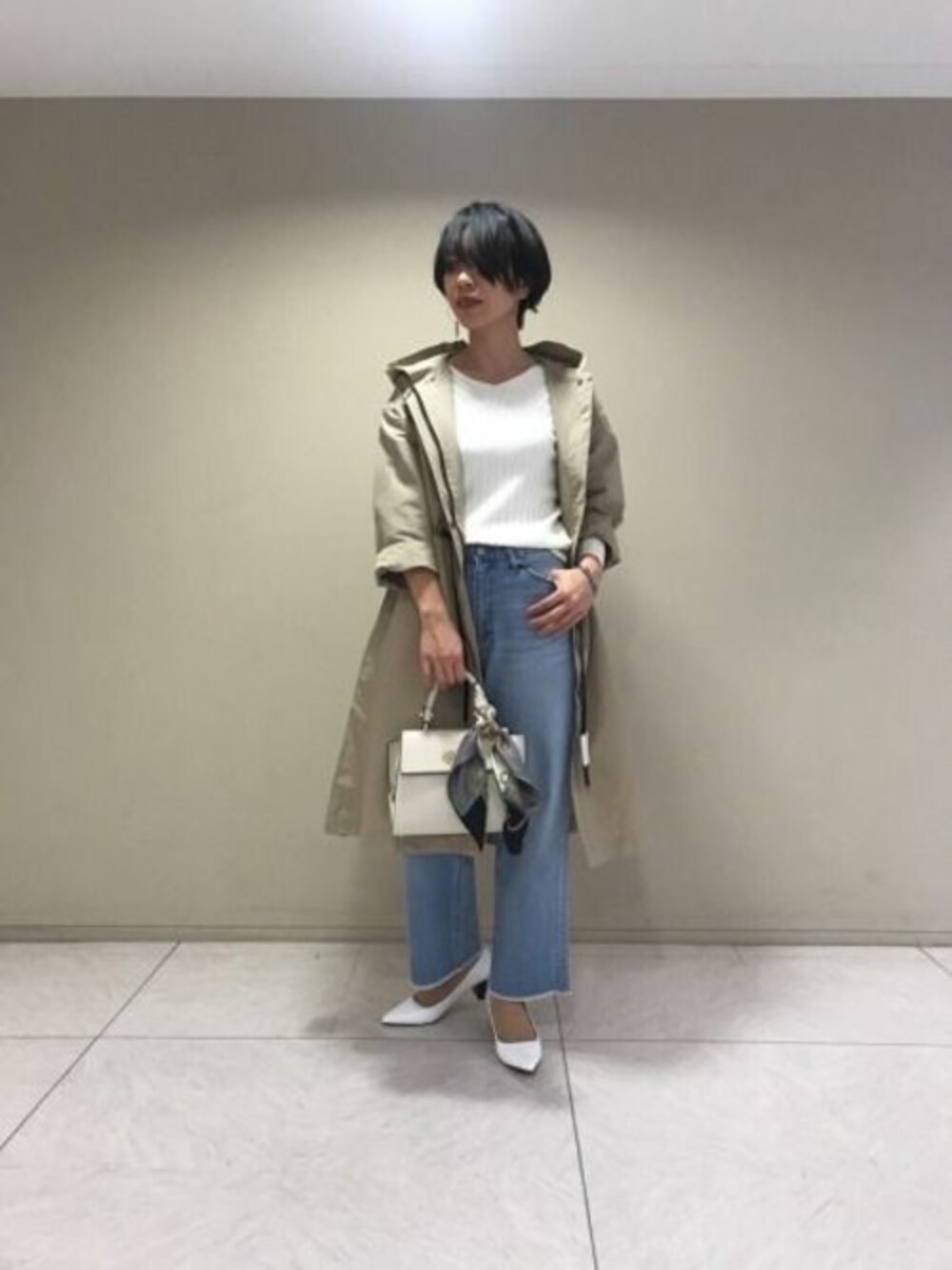 ベージュ系のその他アウター、ホワイト系のニット/セーター、ブルー系のデニムパンツを着用したレディースの冬コーディネートの1枚目の写真