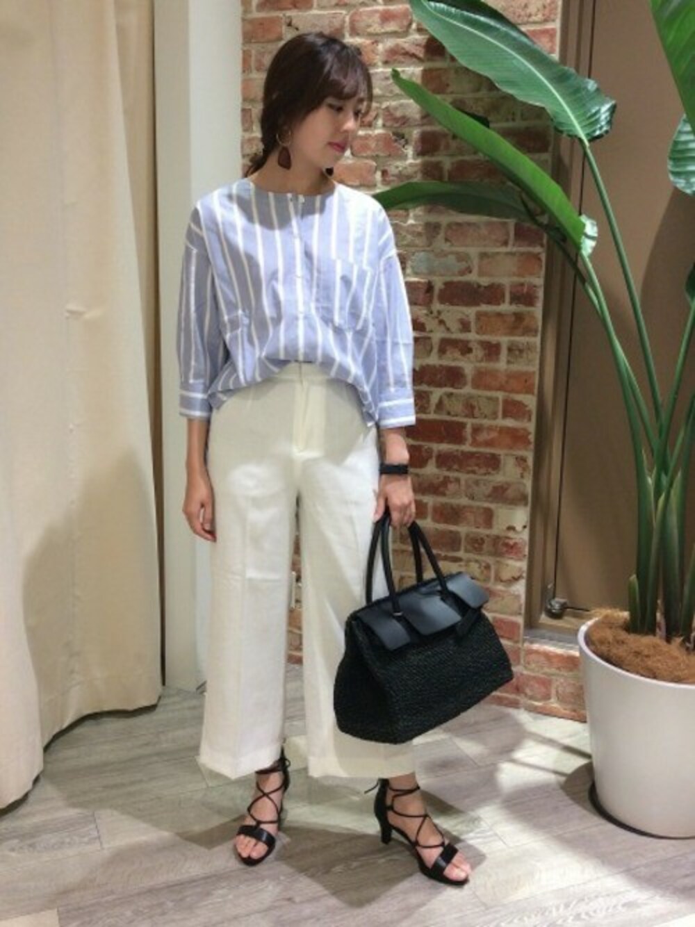 ブルー系のシャツ/ブラウス、ホワイト系のその他パンツ、ブラック系のトートバッグを着用したレディースの春コーディネートの1枚目の写真