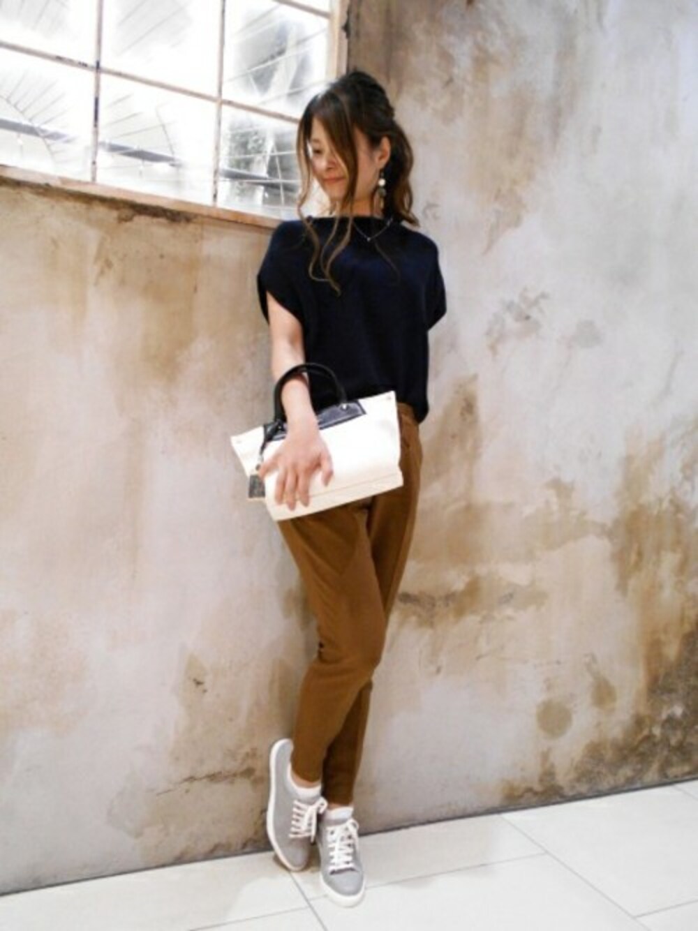 ブルー系のニット/セーター、ブラウン系のその他パンツ、ホワイト系のショルダーバッグを着用したレディースの夏コーディネートの1枚目の写真