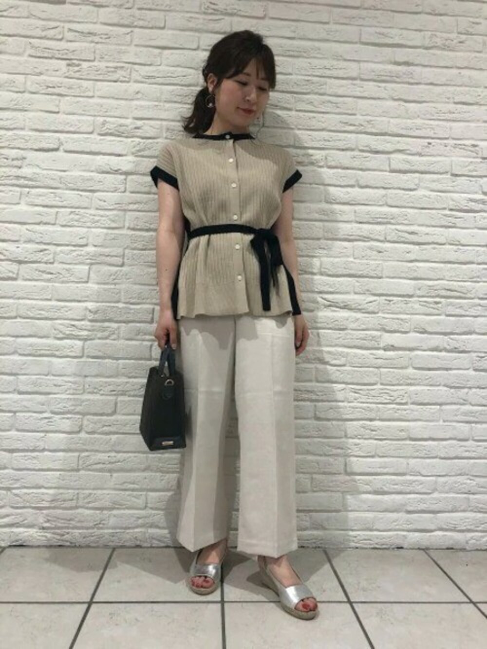 ベージュ系のニット/セーター、ベージュ系のその他パンツ、グレー系のショルダーバッグを着用したレディースの春コーディネートの1枚目の写真