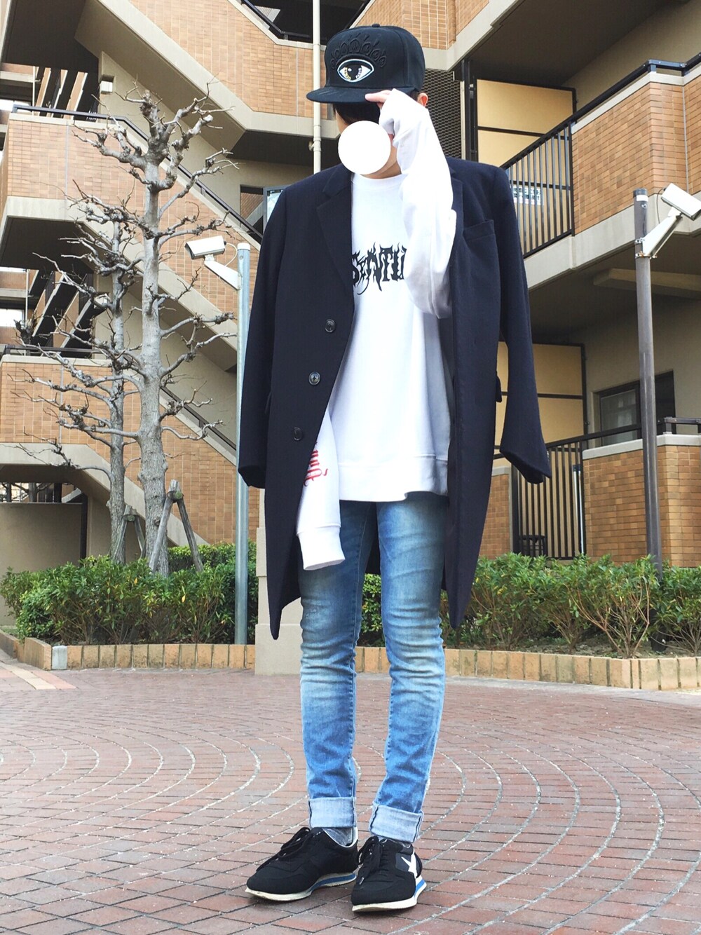 ホワイト系のトップス、ブルー系のパンツ、ブラック系のスニーカーを着用したメンズの冬コーディネートの1枚目の写真