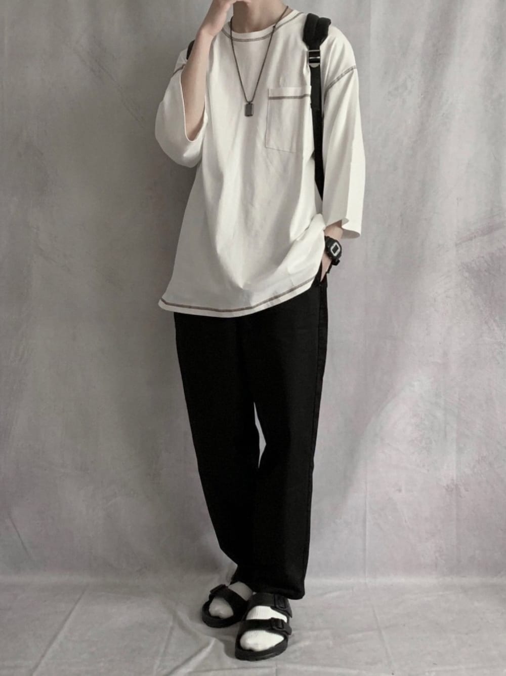 ホワイト系のTシャツ/カットソー、ブラック系のチノパンツ、ブラック系のサンダルを着用したメンズの春コーディネートの1枚目の写真