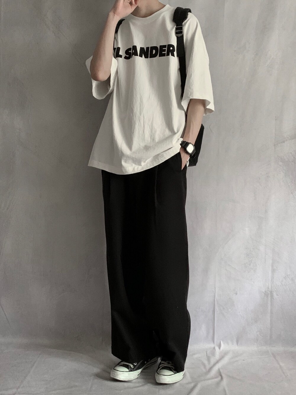 ホワイト系のTシャツ/カットソー、ブラック系のスラックス、ブラック系のスニーカーを着用したメンズの春コーディネートの1枚目の写真