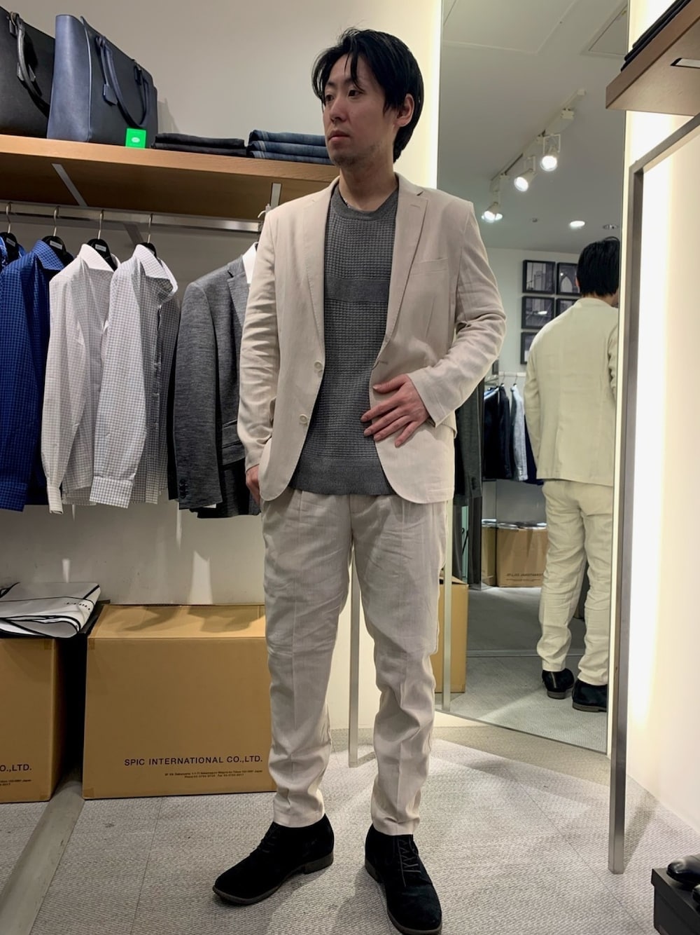 ベージュ系のテーラードジャケット、ベージュ系のスラックス、ブラック系のブーツを着用したメンズの冬コーディネートの1枚目の写真