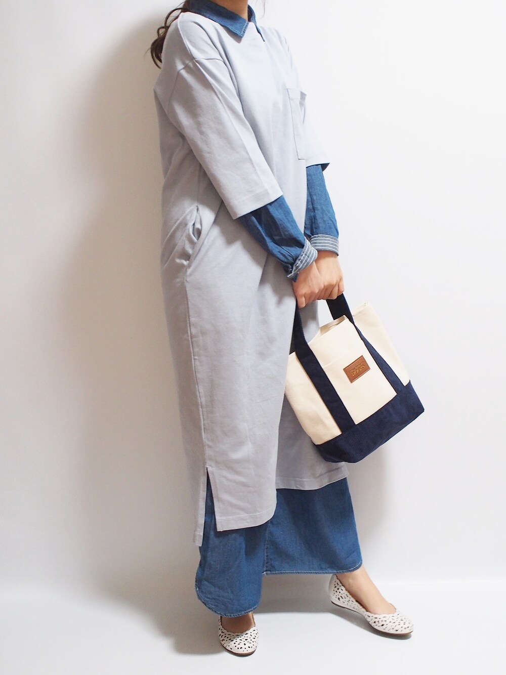 ブラウン系のトートバッグを着用したレディースの春コーディネートの1枚目の写真