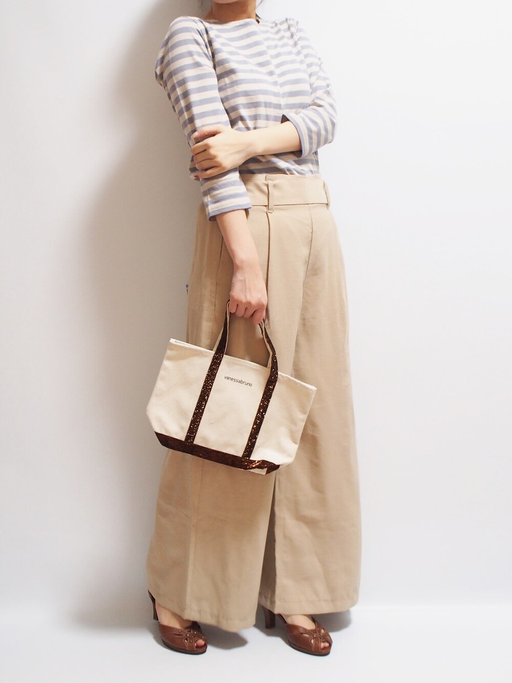 ブラウン系のトートバッグを着用したレディースの春コーディネートの1枚目の写真