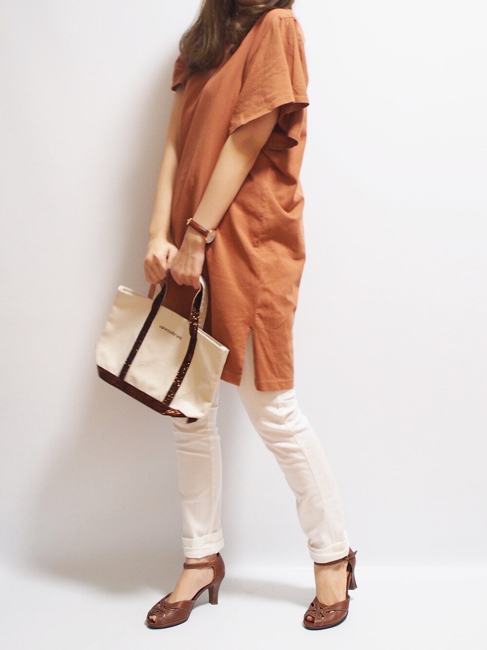 ブラウン系のトートバッグを着用したレディースの春コーディネートの1枚目の写真