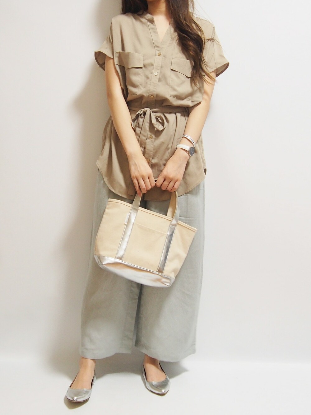 シルバー系のトートバッグを着用したレディースの夏コーディネートの1枚目の写真