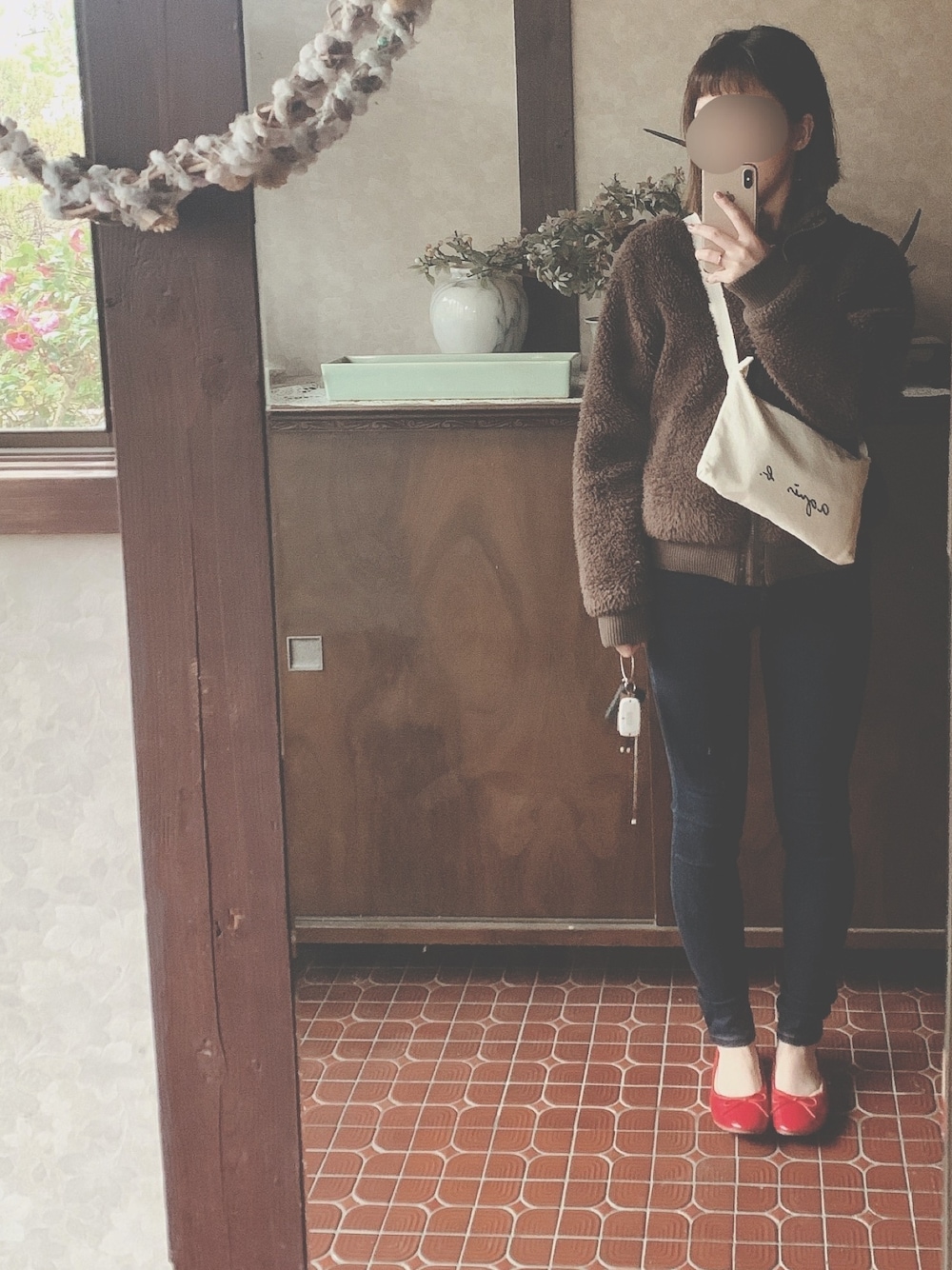 ブルー系のデニムパンツ、レッド系のバレエシューズ、ホワイト系のショルダーバッグを着用したレディースの冬コーディネートの1枚目の写真