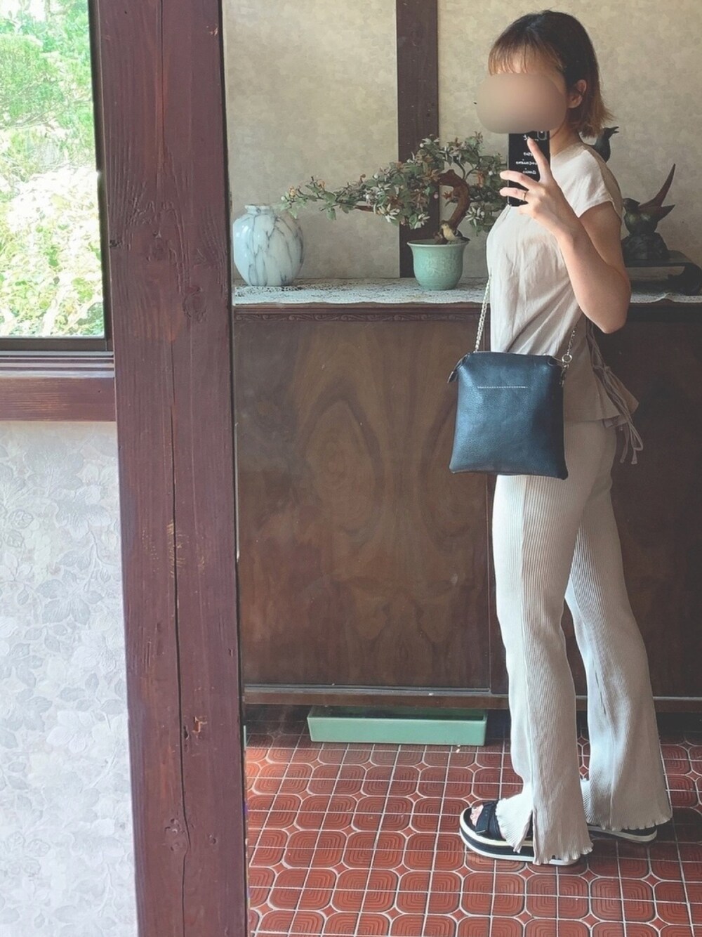 グレー系のトップス、ベージュ系のその他パンツ、ブラック系のサンダルを着用したレディースの夏コーディネートの1枚目の写真