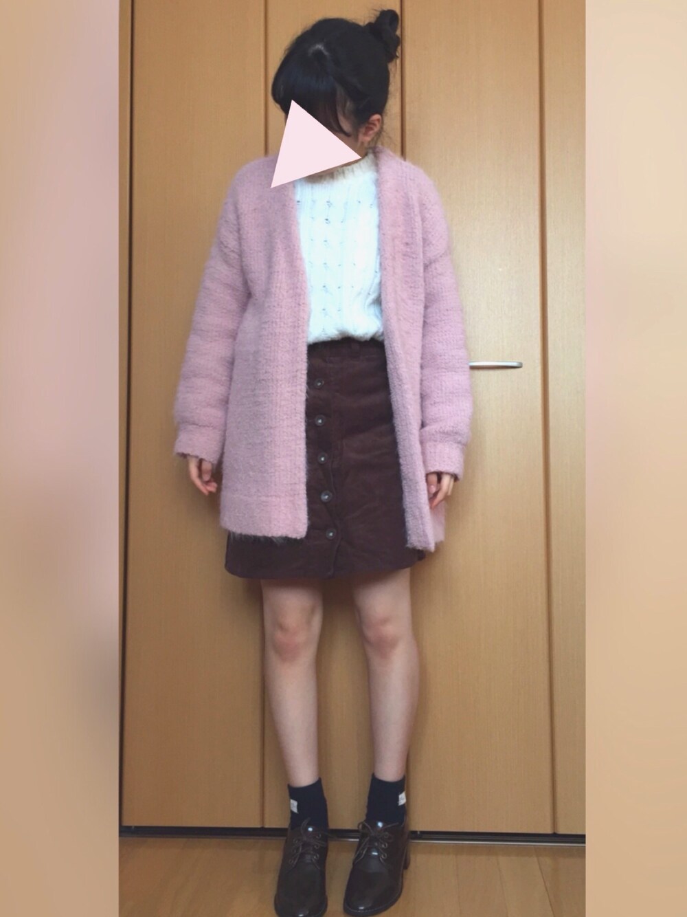 ピンク系のカーディガン/ボレロ、ホワイト系のニット/セーター、ブラウン系のスカートを着用したレディースの冬コーディネートの1枚目の写真