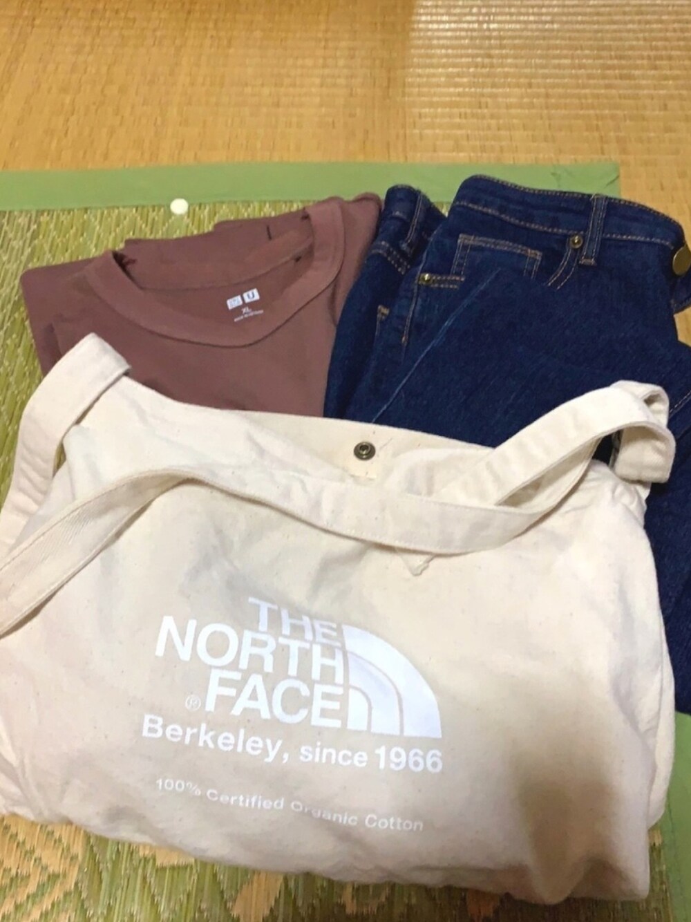 ブルー系のデニムパンツ、ブラウン系のTシャツ/カットソー、ブラック系のドレスシューズを着用したレディースの秋コーディネートの1枚目の写真