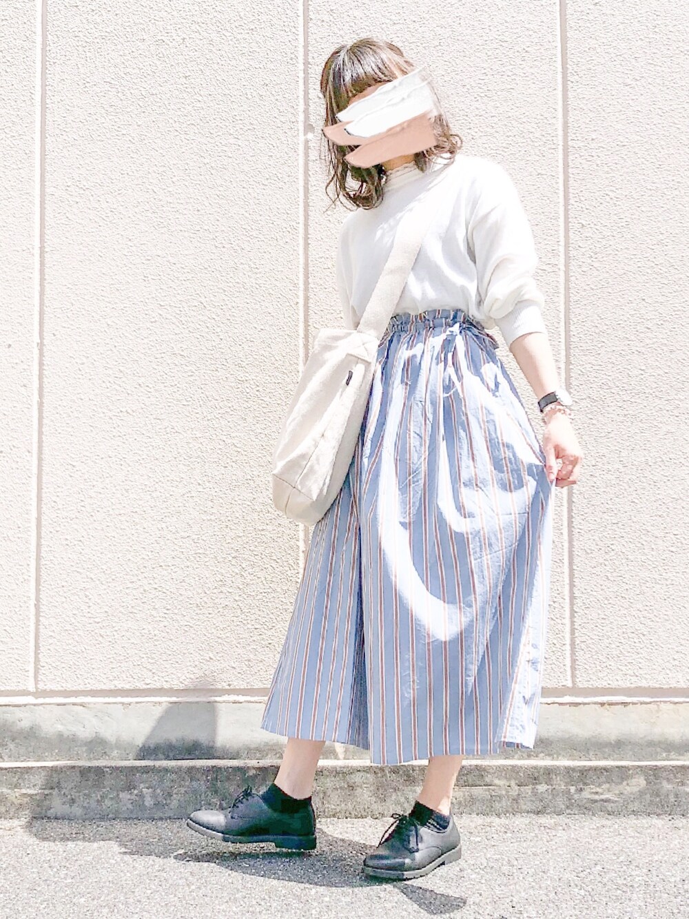 ホワイト系のTシャツ/カットソー、ブルー系のスカート、ブラック系のシューズを着用したレディースの春コーディネートの1枚目の写真