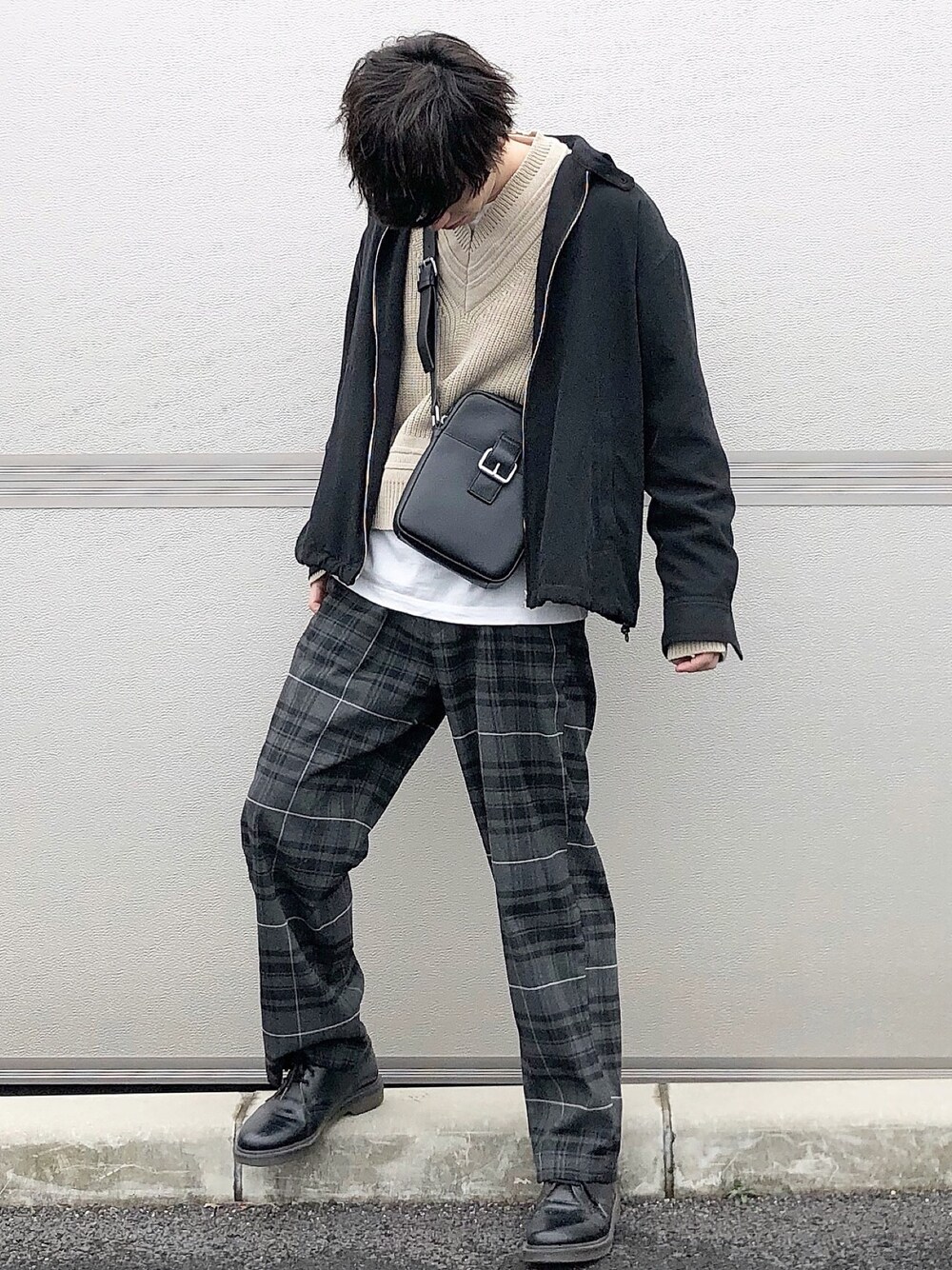 ブラック系のブルゾン、ベージュ系のニット/セーター、ホワイト系のTシャツ/カットソーを着用したメンズの冬コーディネートの1枚目の写真