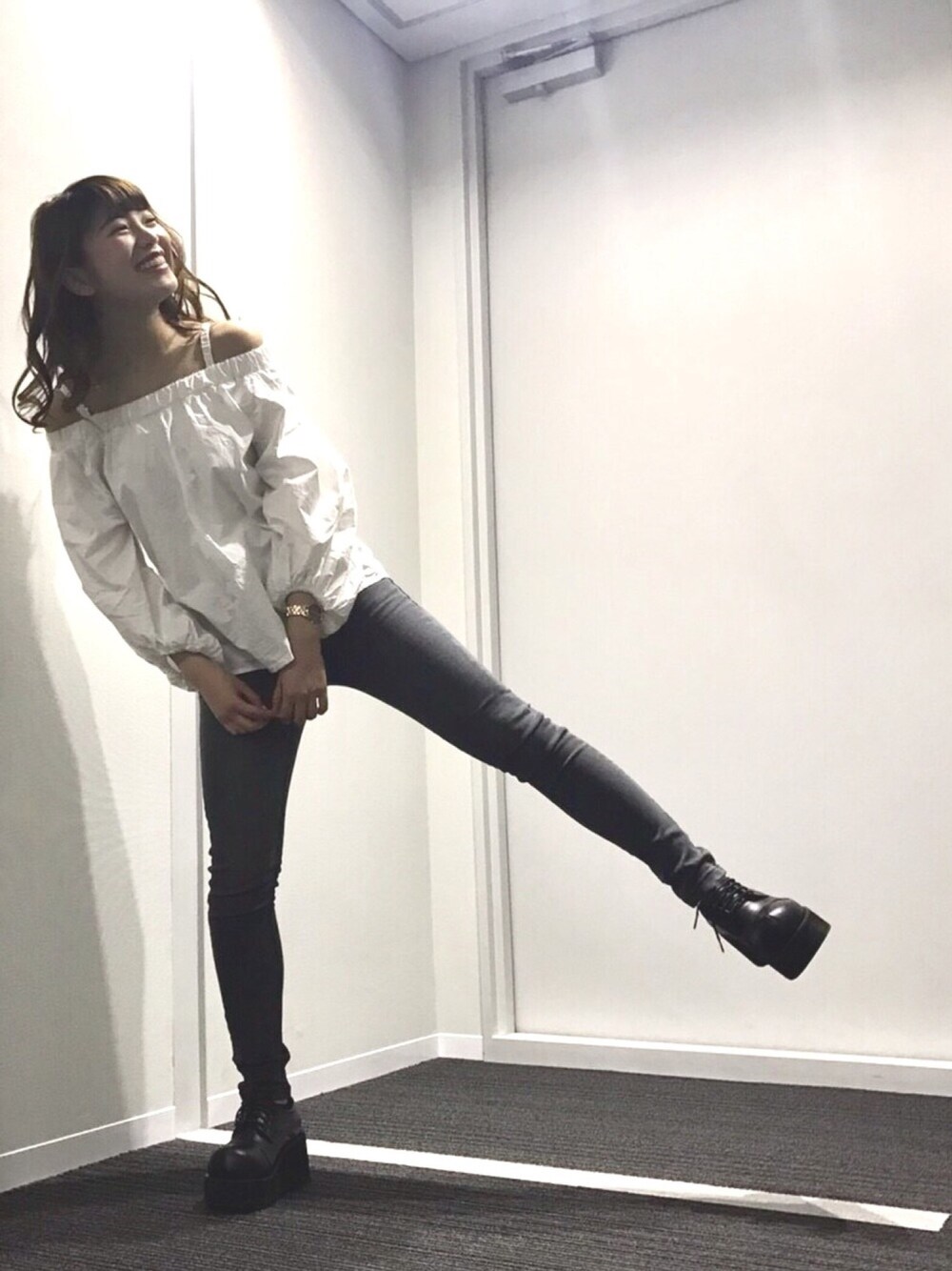 ホワイト系のトップス、グレー系のデニムパンツ、ゴールド系のアナログ腕時計を着用したレディースの春コーディネートの1枚目の写真