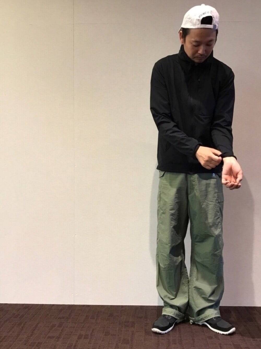 ブラック系のその他アウター、グリーン系のカーゴパンツ、ブラック系のスニーカーを着用したメンズの春コーディネートの1枚目の写真