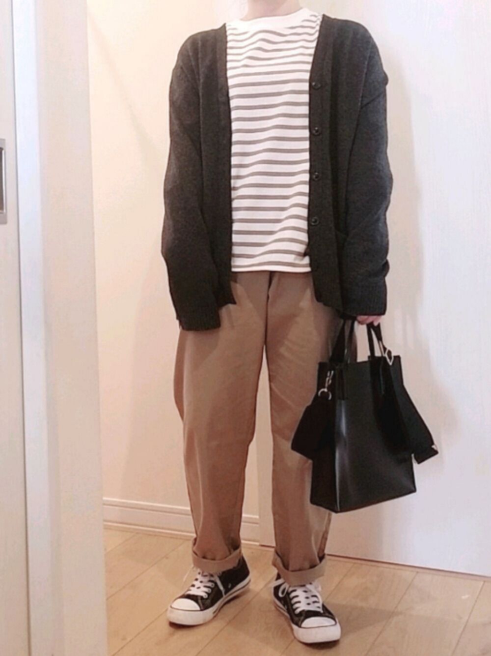 ベージュ系のパンツ、ブラック系のスニーカー、ブラック系のショルダーバッグを着用したレディースの春コーディネートの1枚目の写真