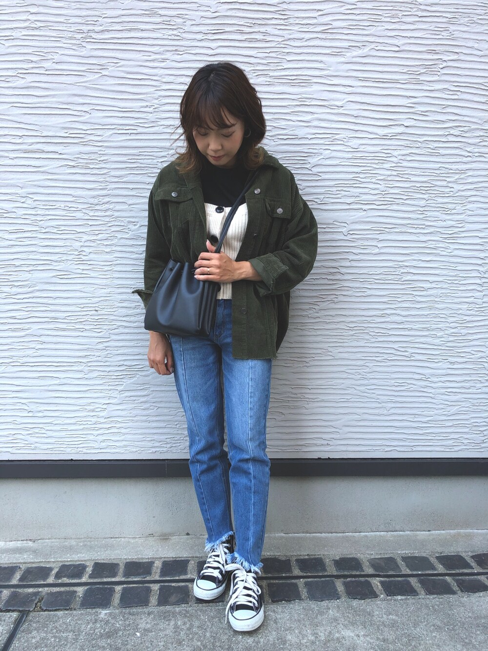 ブルー系のデニムパンツ、ブラック系のショルダーバッグ、ブラック系のスニーカーを着用したレディースの秋コーディネートの1枚目の写真