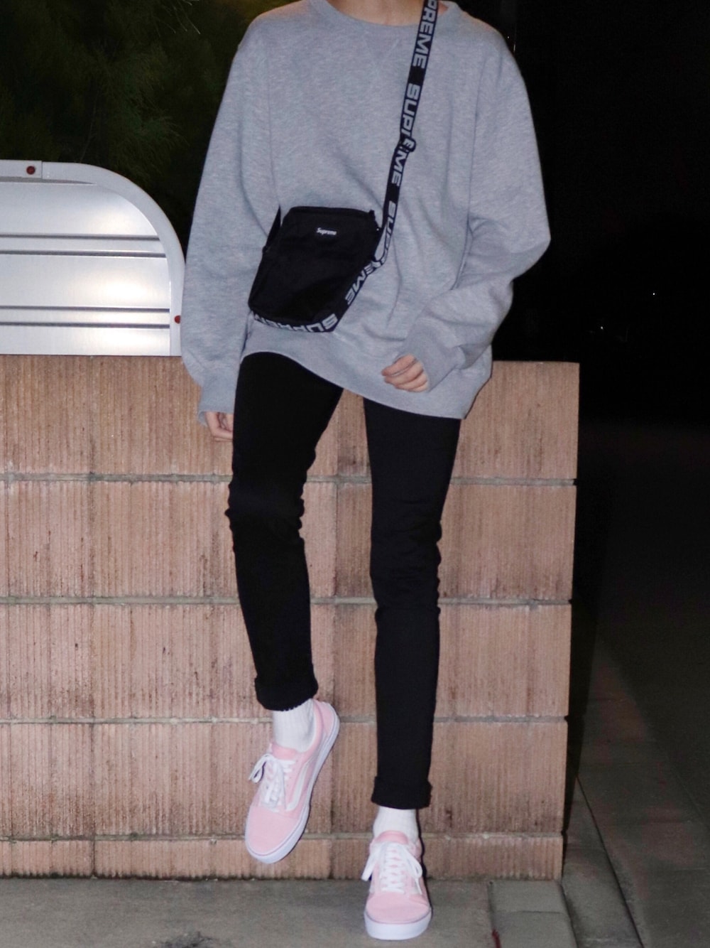 グレー系のスウェット、ブラック系のショルダーバッグ、ブラック系のデニムパンツを着用したメンズの秋コーディネートの1枚目の写真