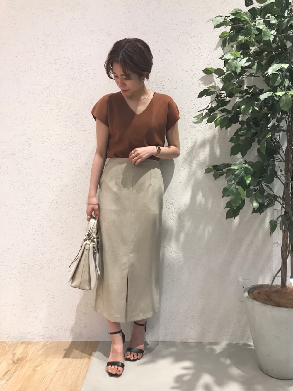 「シンプルコーデ、スカート、オフィスカジュアル、オフィススタイル、オフィス、通勤コーデ、ニット、ブラウン、パーソナルカラー」｜「AndemiuのバックリボンMYカラーニット911033（ニット/セーター、ブラウン系）」を使った、Andemiu STAFFさん（レディース・158cm）の春コーディネートの1枚目の写真
