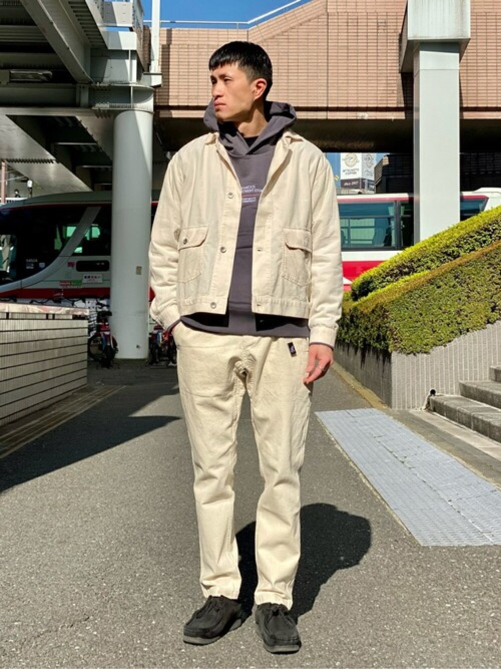 ベージュ系のデニムパンツ、ホワイト系のブルゾン、ブラック系のパーカーを着用したメンズの冬コーディネートの1枚目の写真