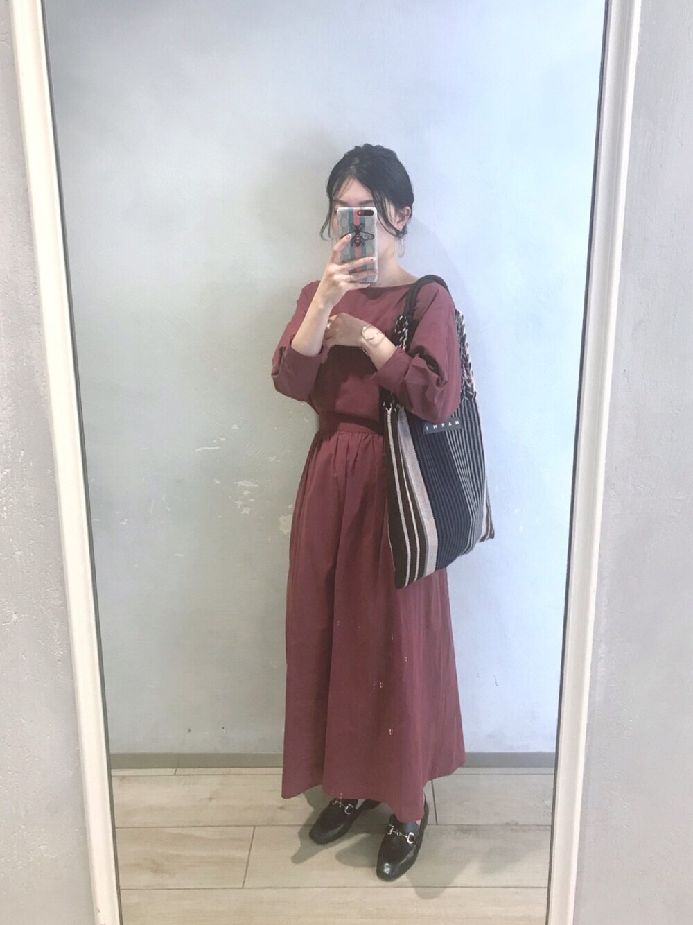 ブラウン系のワンピース、ブルー系のバッグ、ブラック系のローファーを着用したレディースの夏コーディネートの1枚目の写真