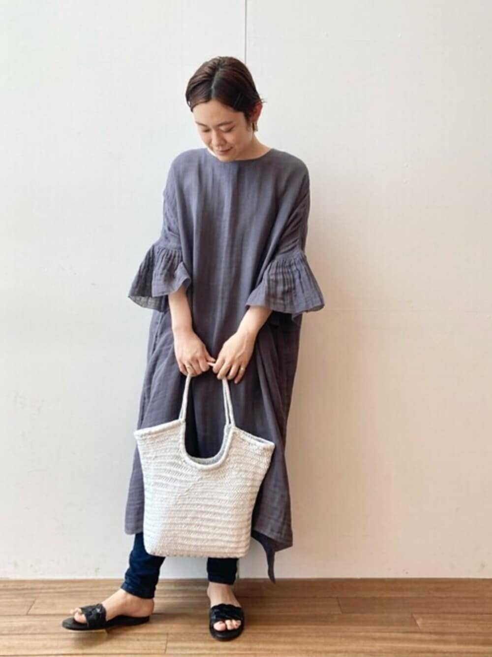 グレー系のワンピース、ブルー系のデニムパンツ、グレー系のTシャツ/カットソーを着用したレディースの春コーディネートの1枚目の写真
