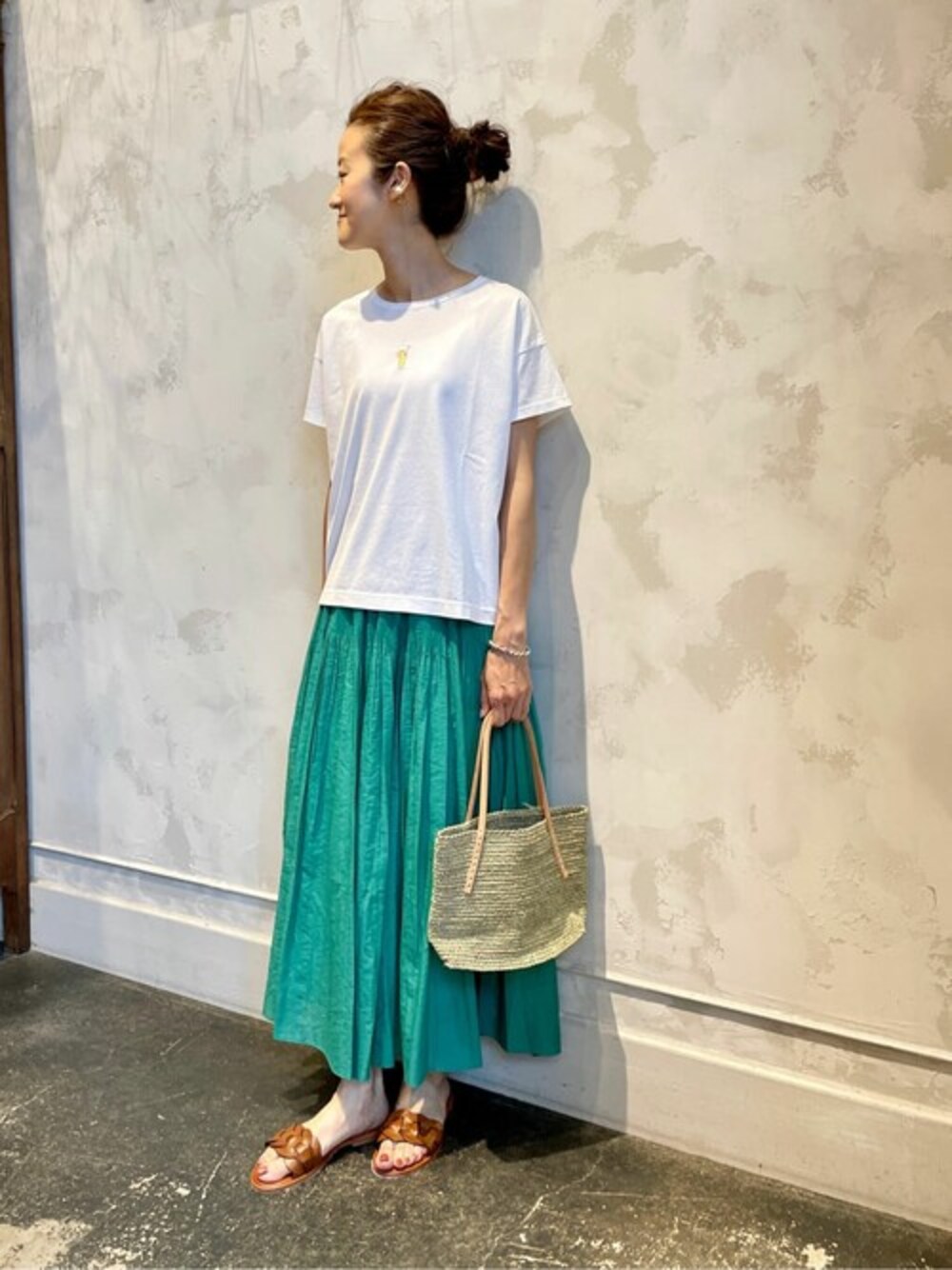 ホワイト系のTシャツ/カットソー、グリーン系のスカート、イエロー系のトートバッグを着用したレディースの夏コーディネートの1枚目の写真