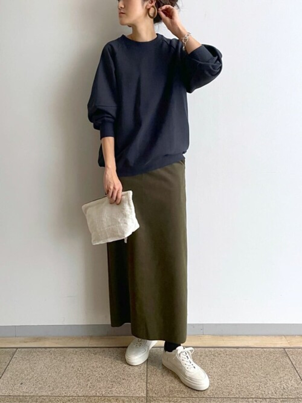 ブルー系のTシャツ/カットソー、グリーン系のスカート、ブルー系のスニーカーを着用したレディースの冬コーディネートの1枚目の写真