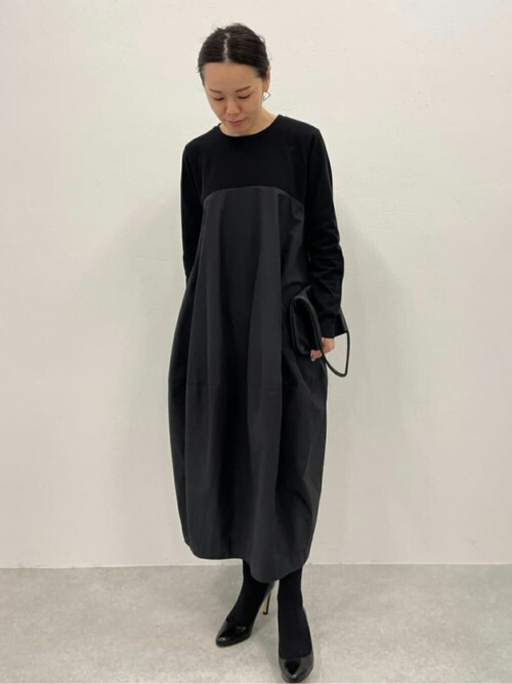 ブラック系のワンピースを着用したレディースの冬コーディネートの1枚目の写真