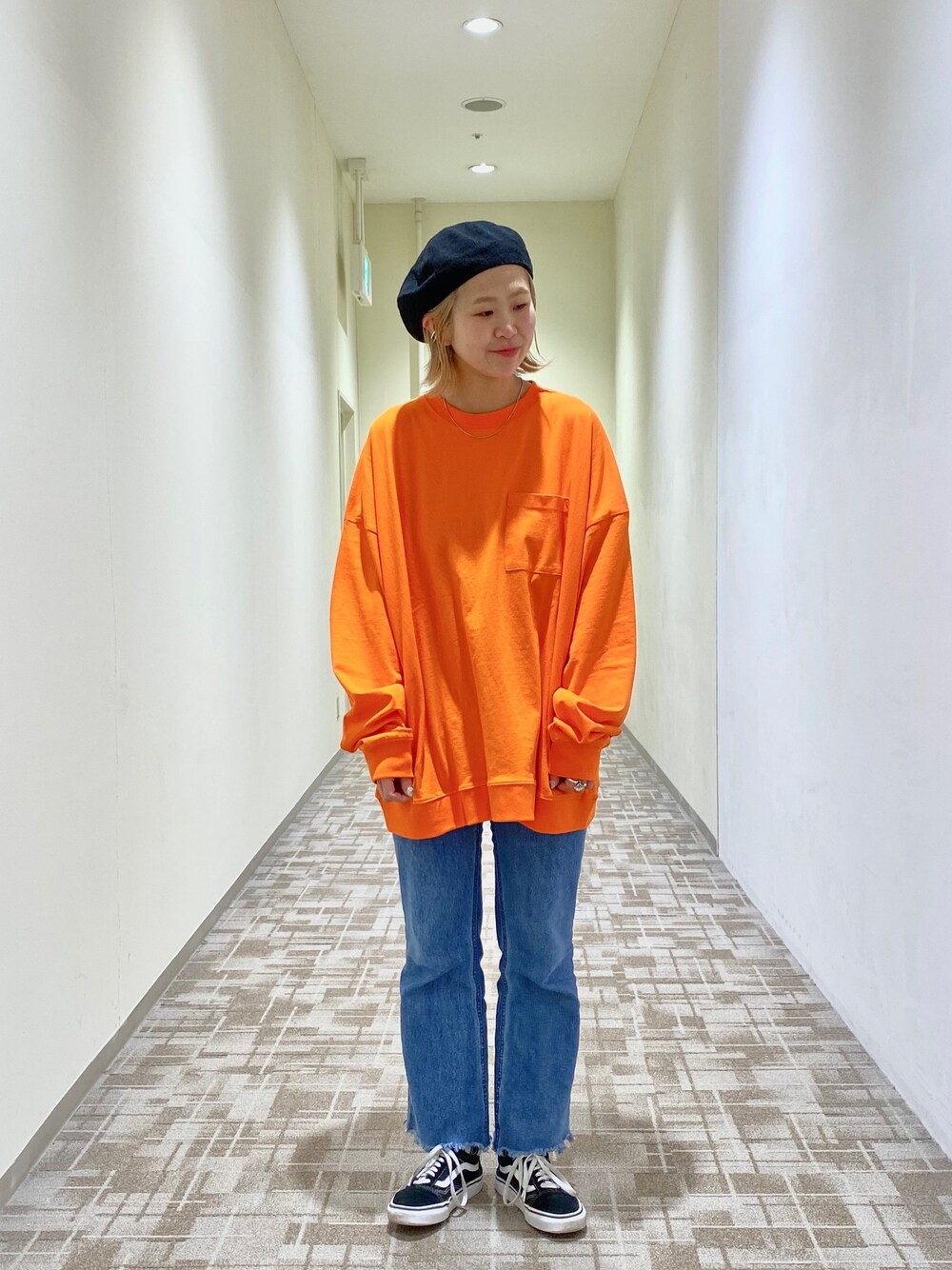 オレンジ系のTシャツ/カットソー、ブルー系のデニムパンツを着用したレディースの春コーディネートの1枚目の写真