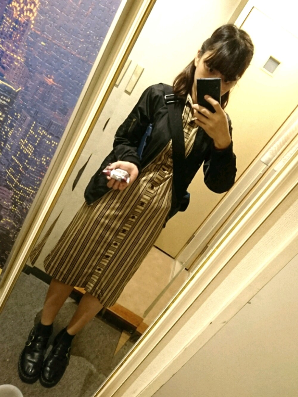 ブラック系のブルゾン、ブルー系のメッセンジャーバッグ、ブラック系のドレスシューズを着用したレディースの秋コーディネートの1枚目の写真