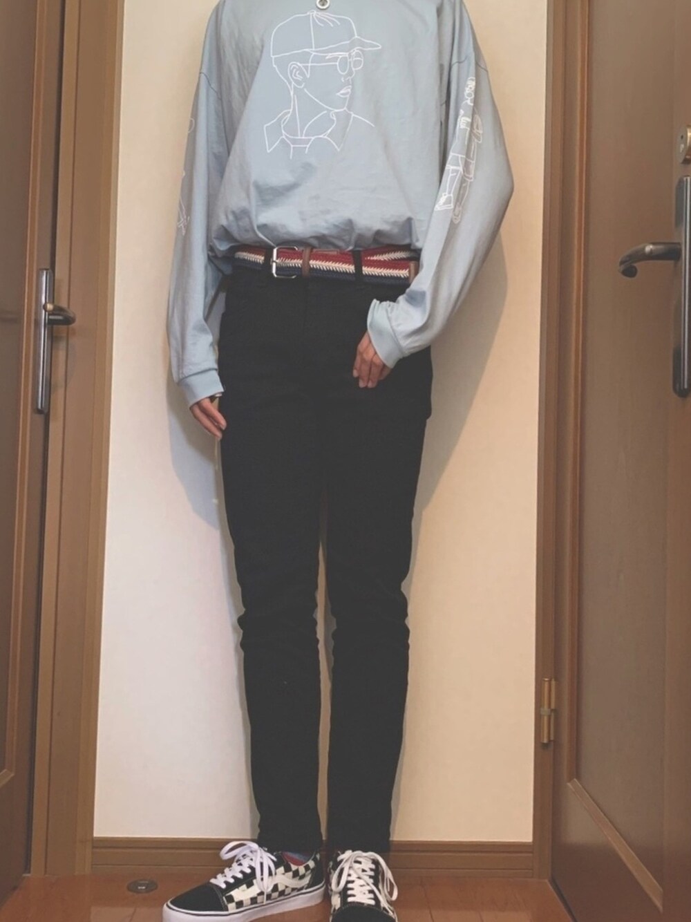 ブラック系のスラックス、ブラック系のスニーカー、ブルー系のTシャツ/カットソーを着用したメンズの春コーディネートの1枚目の写真