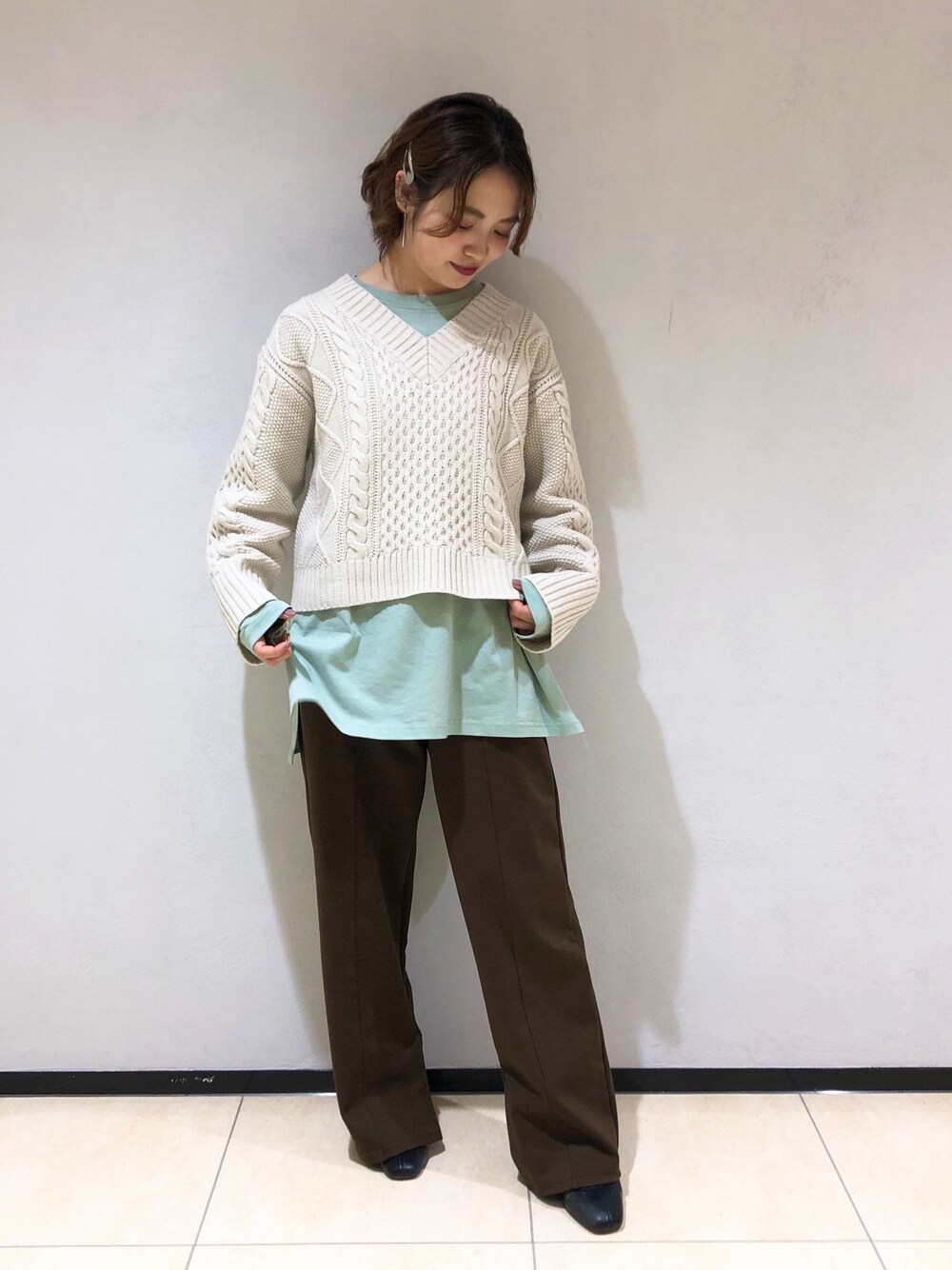 ブラウン系のその他パンツ、ブラック系のブーツ、グリーン系のTシャツ/カットソーを着用したレディースの冬コーディネートの1枚目の写真