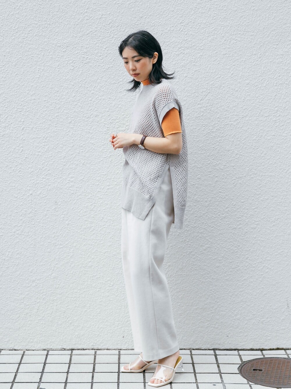 オレンジ系のTシャツ/カットソー、ベージュ系のトップス、ホワイト系のその他パンツを着用したレディースの春コーディネートの1枚目の写真