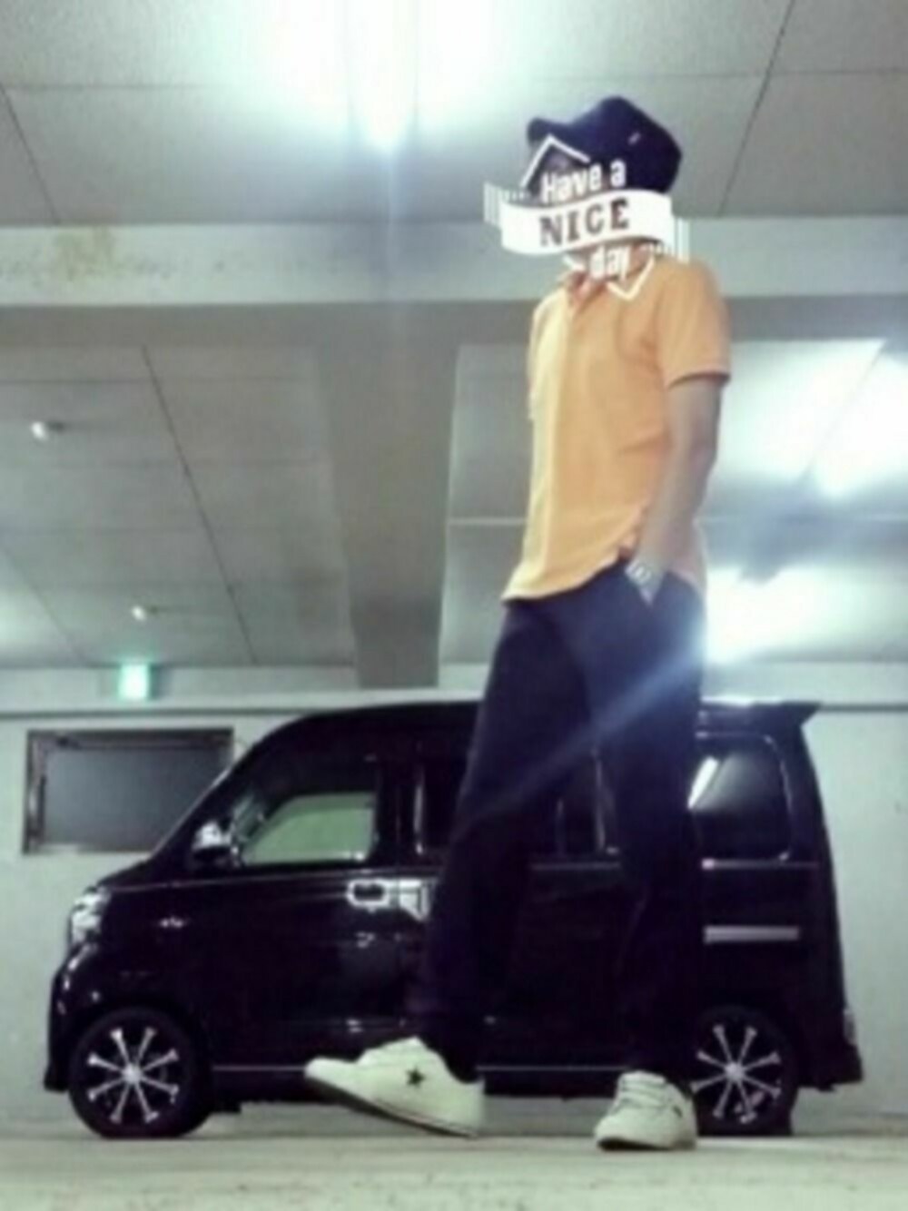 ホワイト系のスニーカー、オレンジ系のポロシャツを着用したメンズの夏コーディネートの1枚目の写真