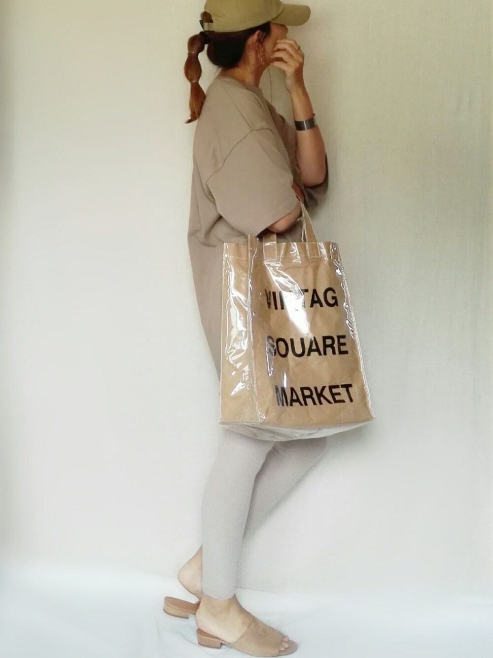 ベージュ系のサンダル、グリーン系のトートバッグ、ベージュ系のTシャツ/カットソーを着用したレディースの春コーディネートの1枚目の写真