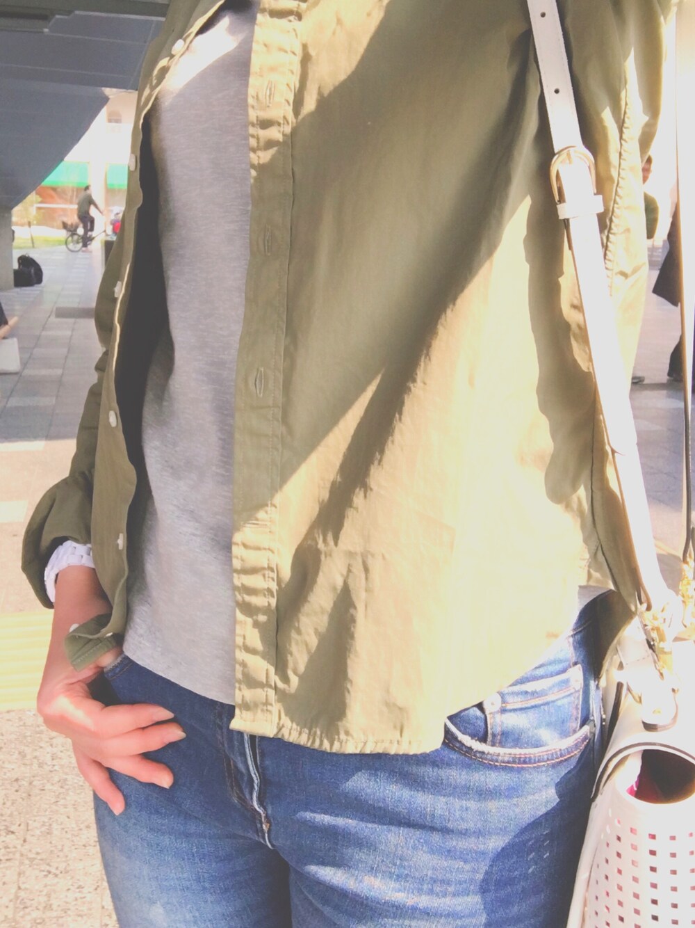 グリーン系のシャツ/ブラウス、グレー系のTシャツ/カットソー、ブルー系のデニムパンツを着用したレディースの春コーディネートの1枚目の写真