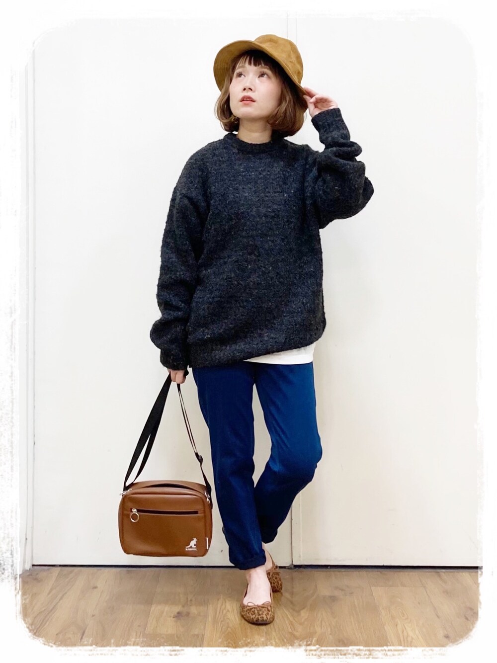 ブラック系のニット/セーター、ブルー系のその他パンツ、ブラウン系のショルダーバッグを着用したレディースの冬コーディネートの1枚目の写真