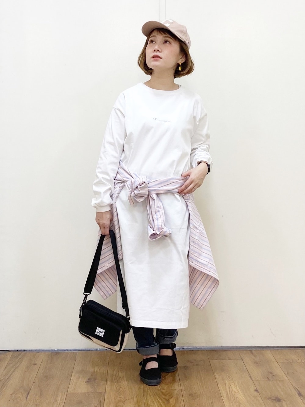 ホワイト系のワンピース、ブラック系のショルダーバッグ、ブルー系のデニムパンツを着用したレディースの冬コーディネートの1枚目の写真