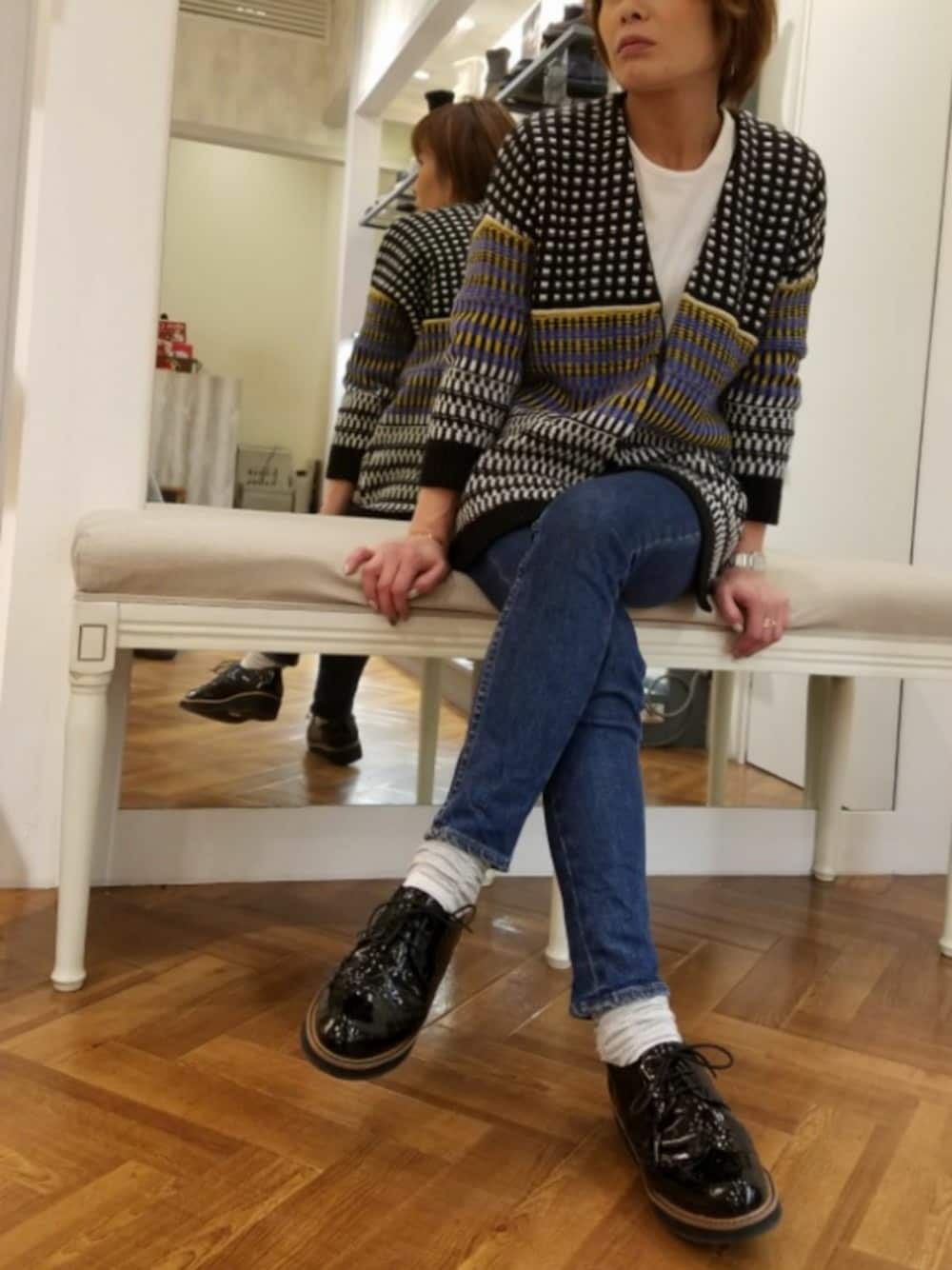 その他のドレスシューズ、ブラック系のカーディガン/ボレロ、ブルー系のパンツを着用したレディースの冬コーディネートの1枚目の写真