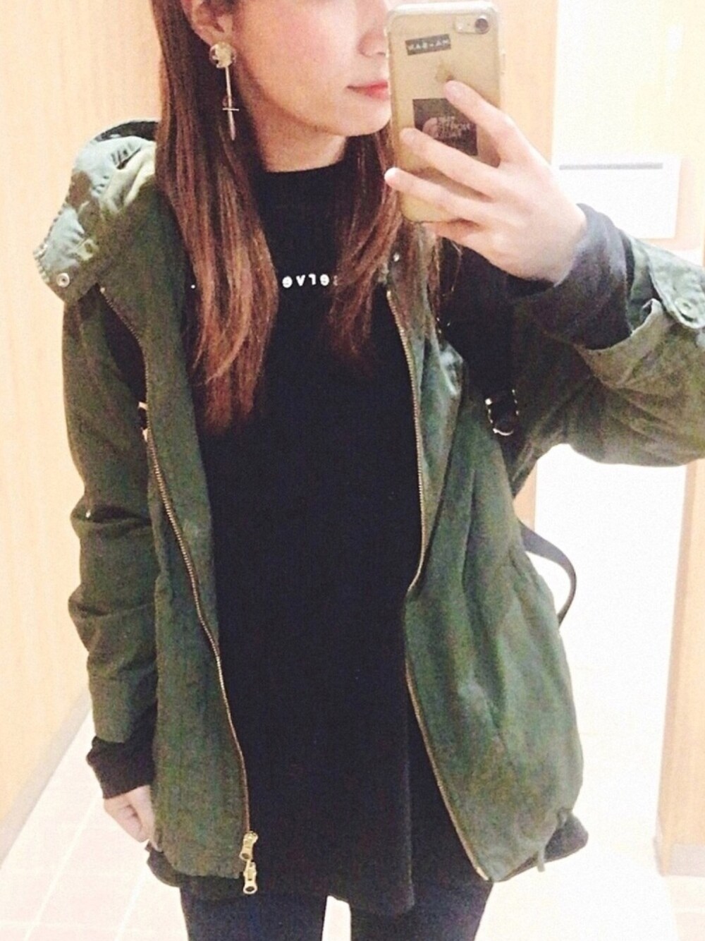 ブラック系のTシャツ/カットソー、グリーン系のマウンテンパーカー、ブラック系のバックパック/リュックを着用したレディースの春コーディネートの1枚目の写真