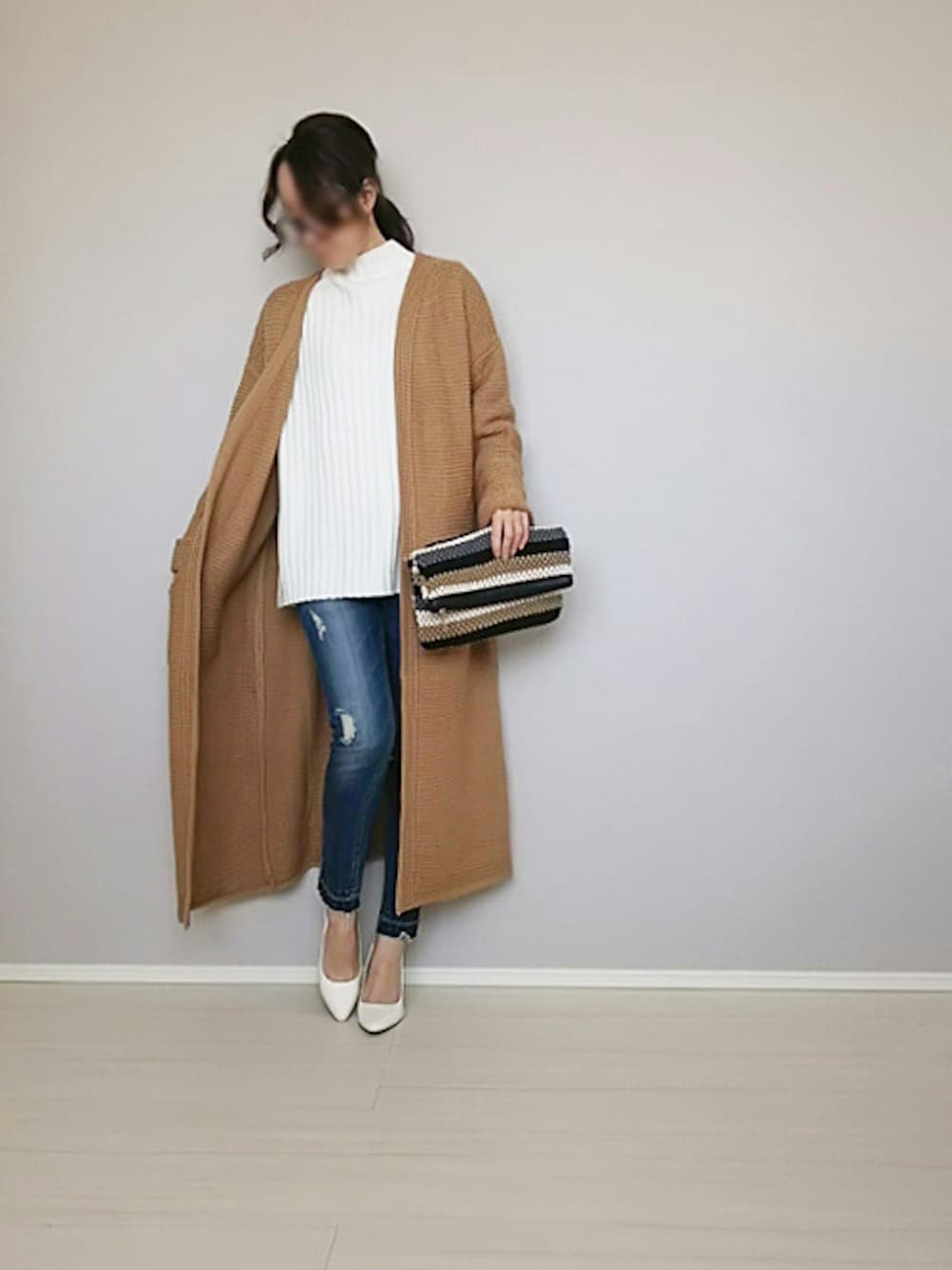 ホワイト系のニット/セーター、イエロー系のカーディガン/ボレロ、ブルー系のデニムパンツを着用したレディースの冬コーディネートの1枚目の写真