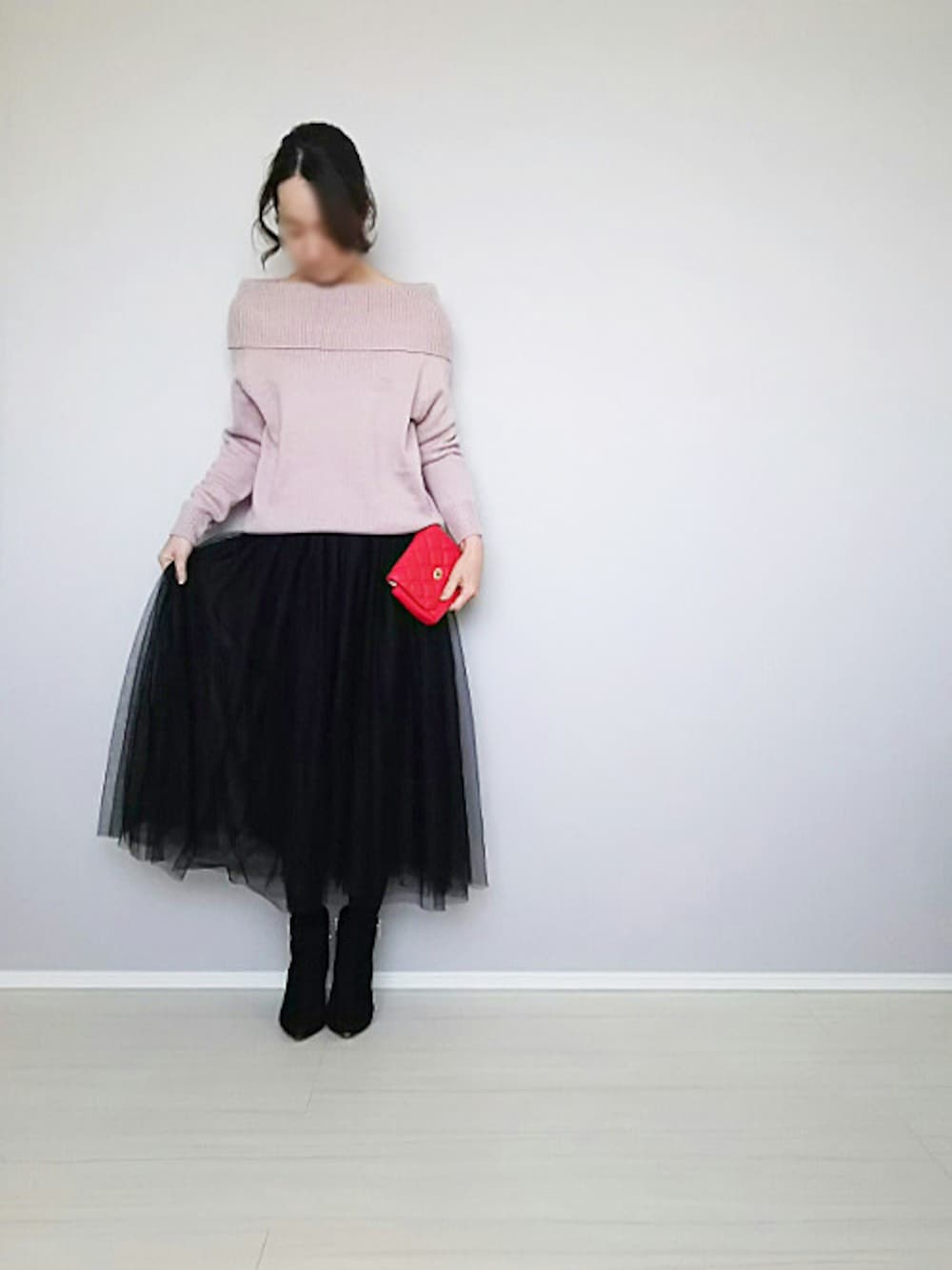 ブラック系のスカート、ブラック系のブーツを着用したレディースの春コーディネートの1枚目の写真