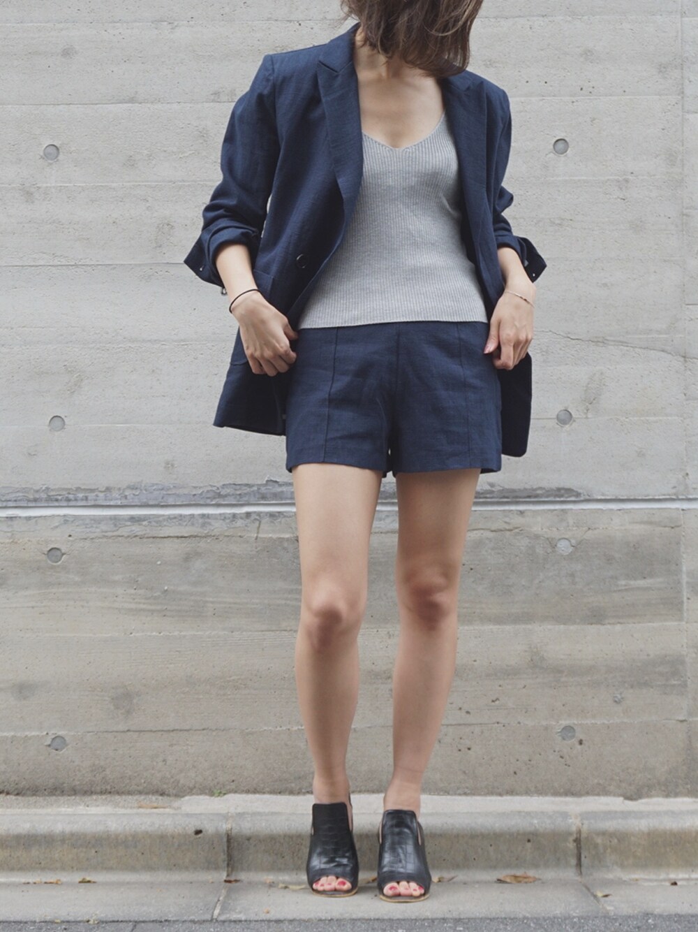 ブルー系のテーラードジャケット、ブルー系のパンツ、ブラック系のブーティを着用したレディースの春コーディネートの1枚目の写真