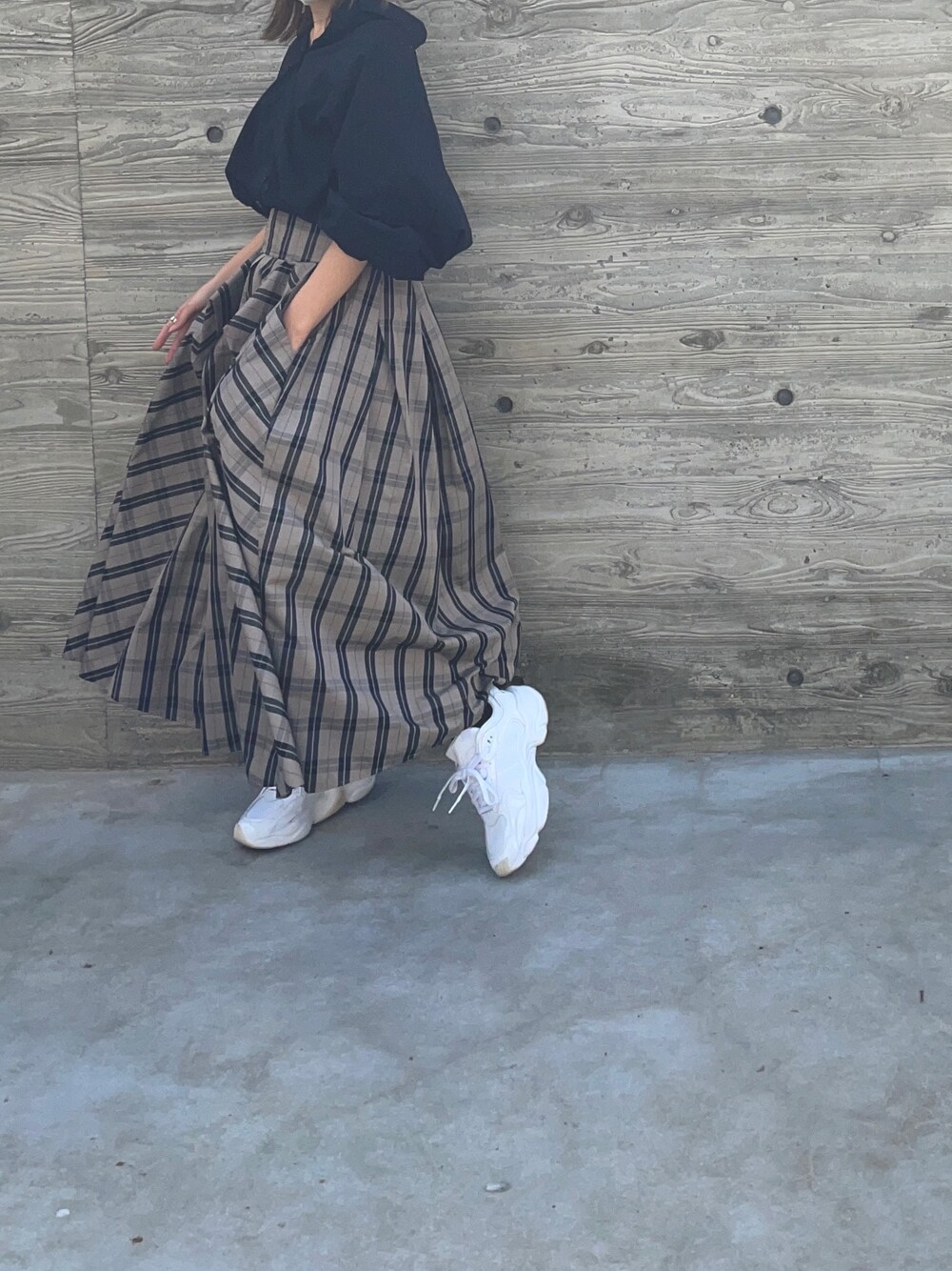 その他のスカート、ホワイト系のスニーカー、ブラック系のシャツ/ブラウスを着用したレディースの春コーディネートの1枚目の写真